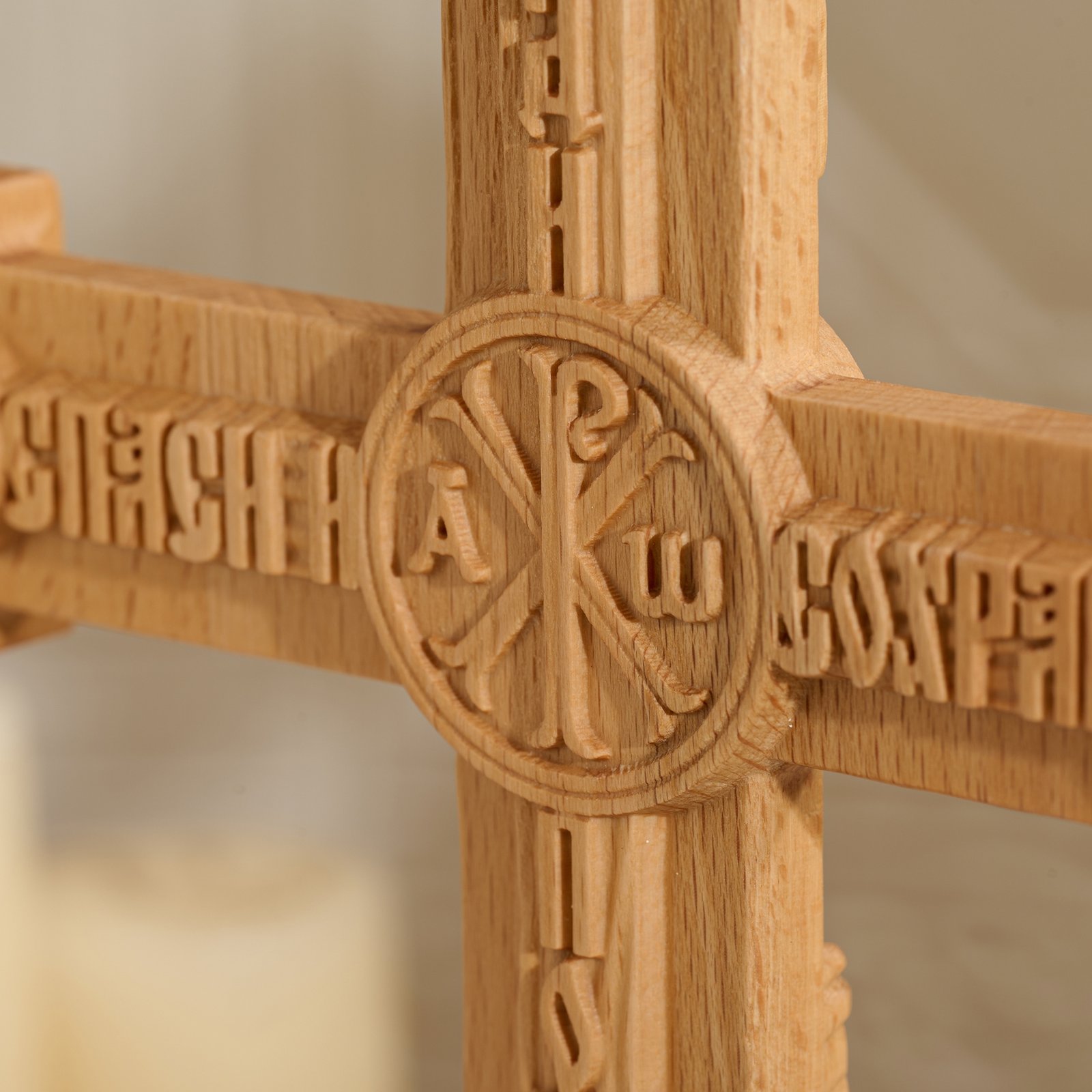Close up of back center carving detail on Orthodox crucifix showing Eastern Christian symbols and engraved lettering