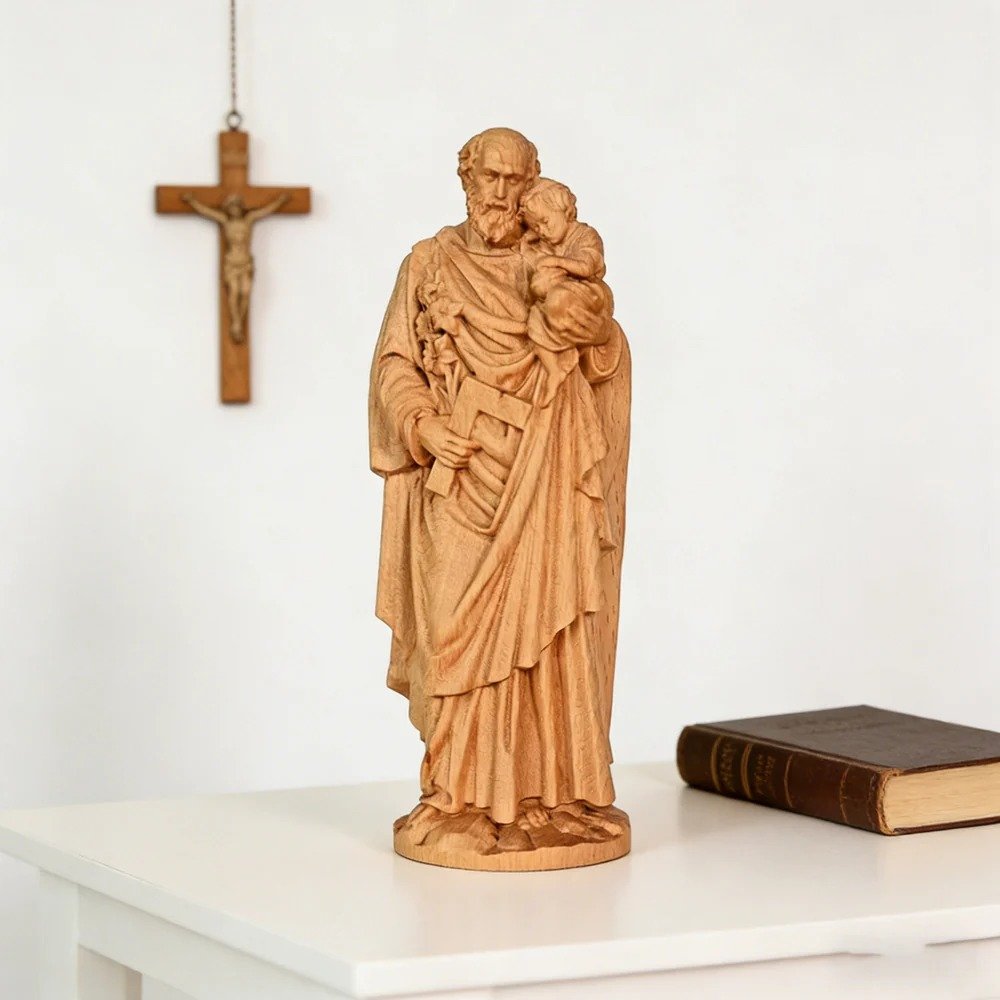 Saint Joseph wooden statue with Child Jesus displayed beside a Christian cross and religious book
