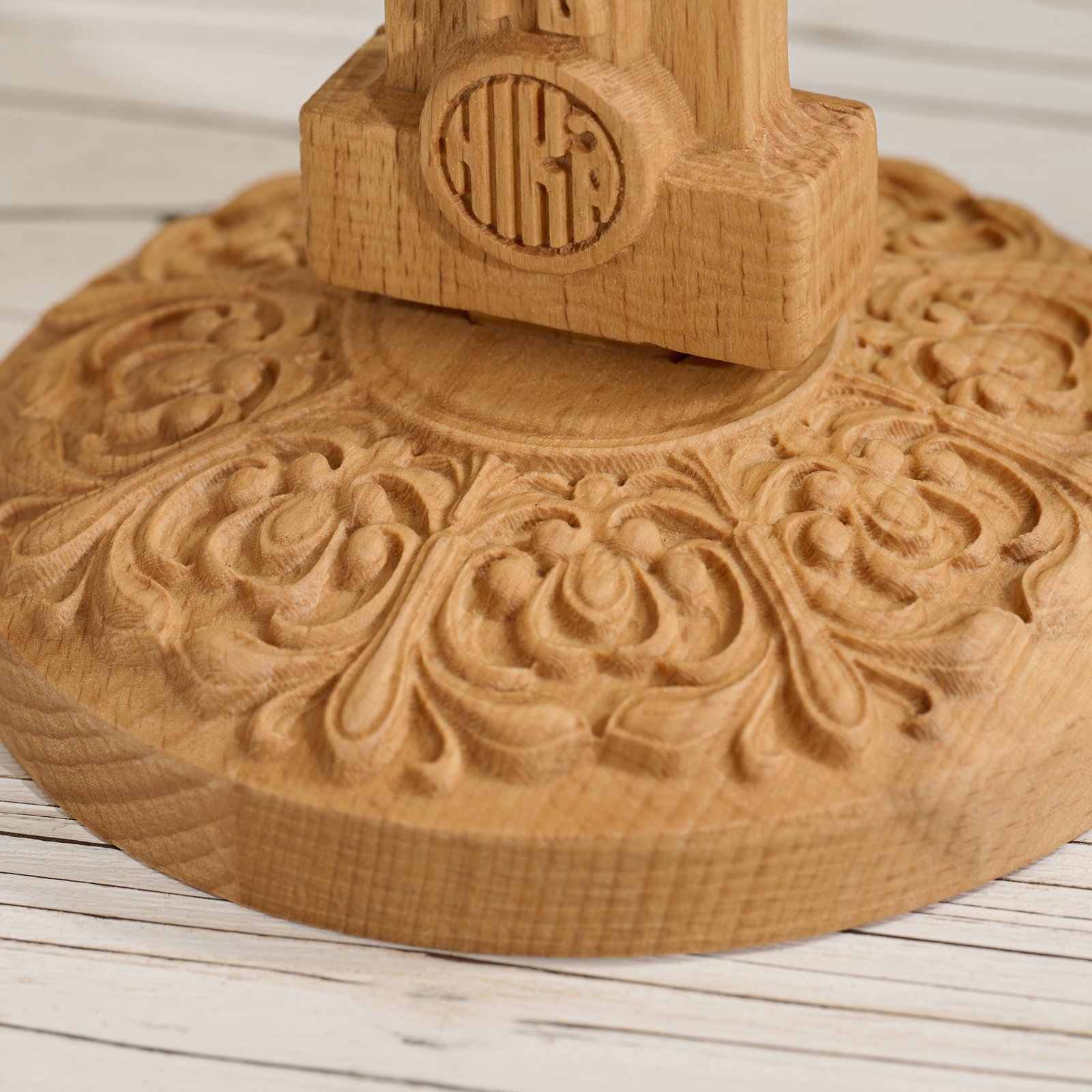 Close up of decorative base detail on Orthodox wooden crucifix showing floral carving craftsmanship