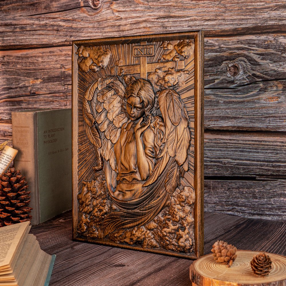Hand carved Female Angel wood relief displayed on a wooden table with rustic background