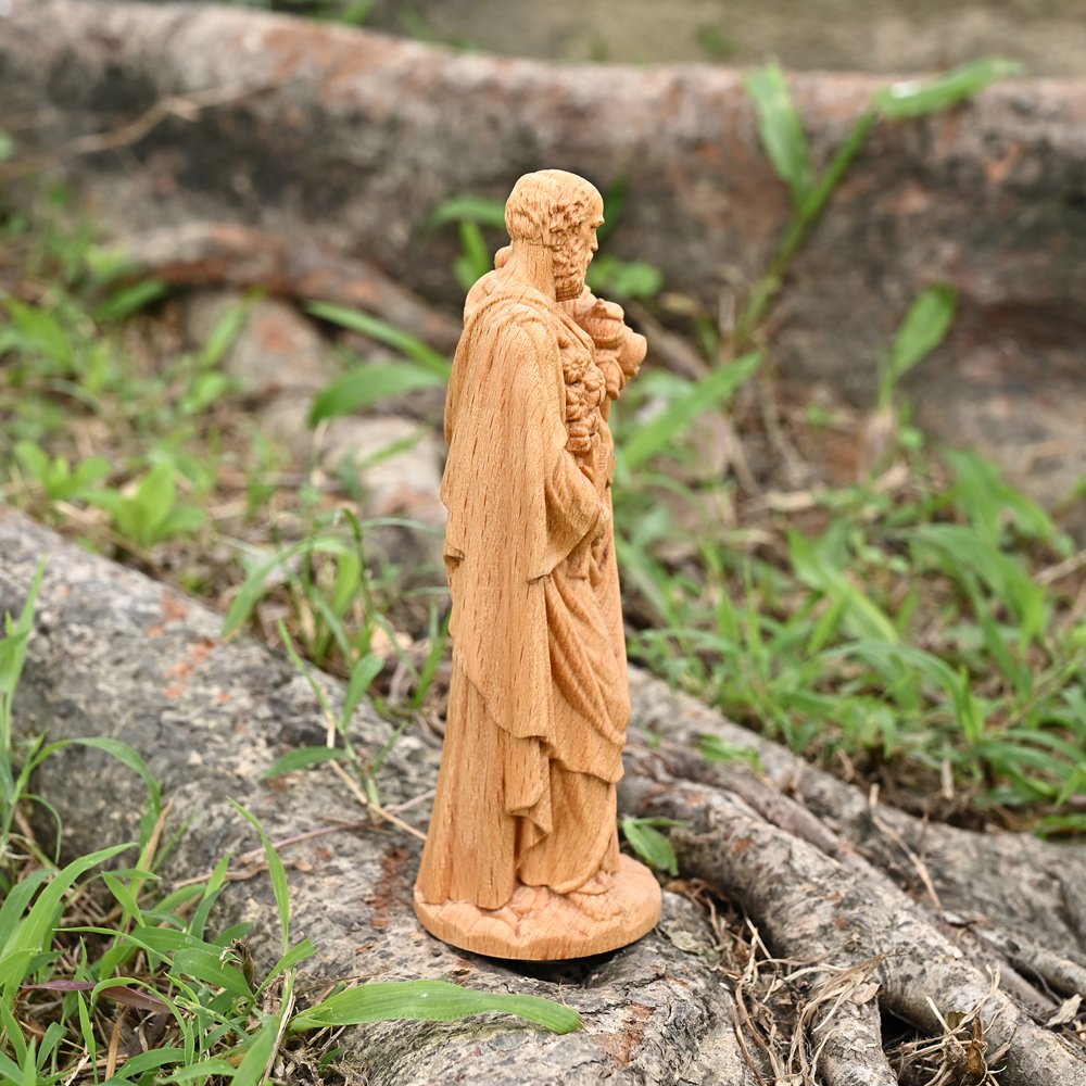 Hand carved Saint Joseph statue made from natural wood displayed outdoors with visible wood grain