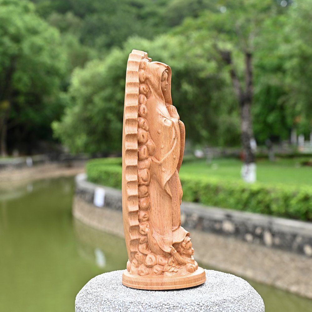 Side profile of handmade wooden religious statue showing carving depth and solid wood construction