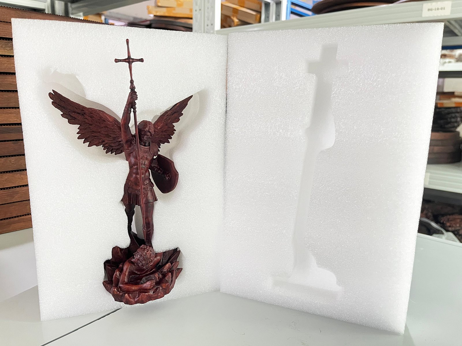 Wooden angel statue secured inside custom contour-cut foam packaging