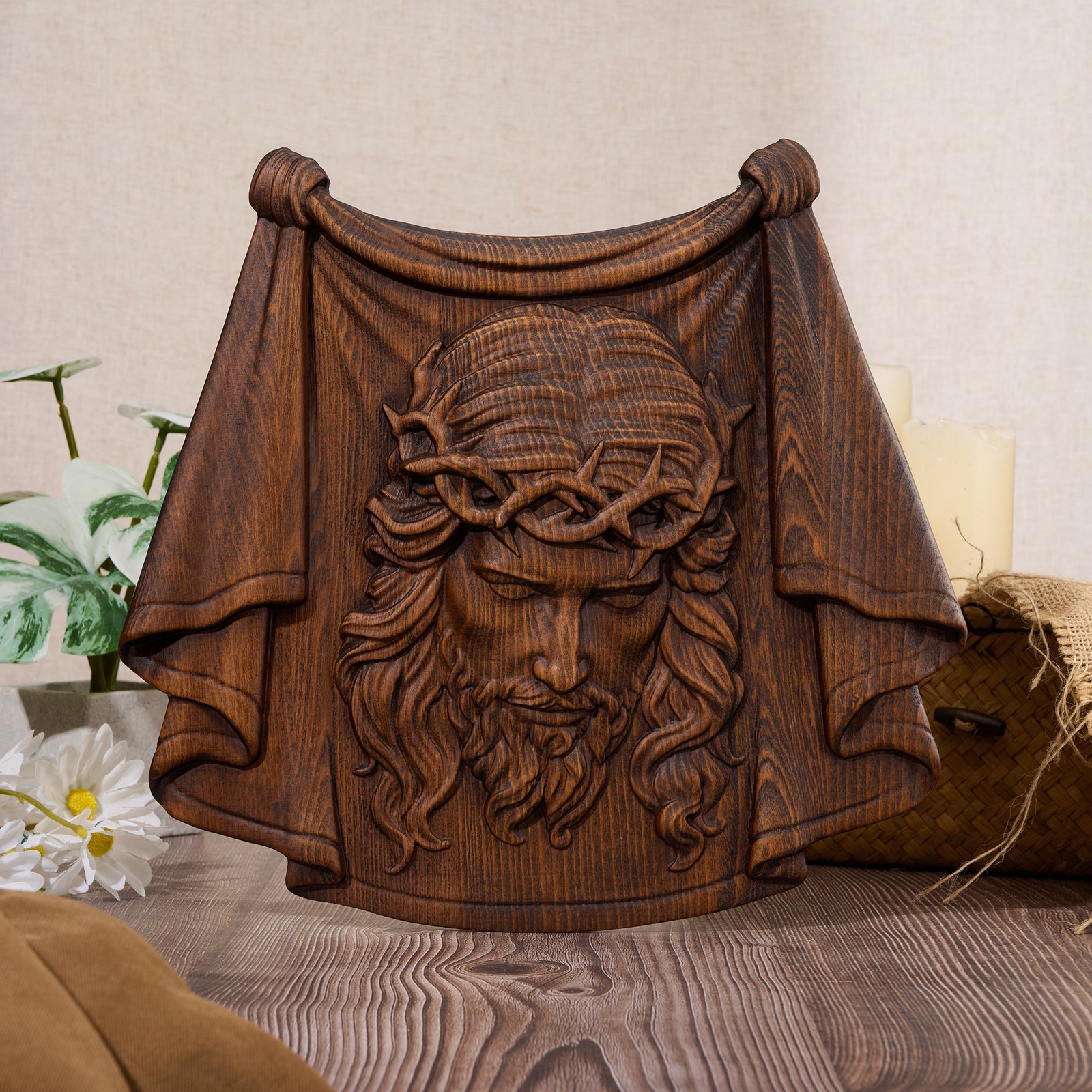 Antique wood Jesus face wall carving featuring a crown of thorns and draped veil, displayed on a tabletop setting