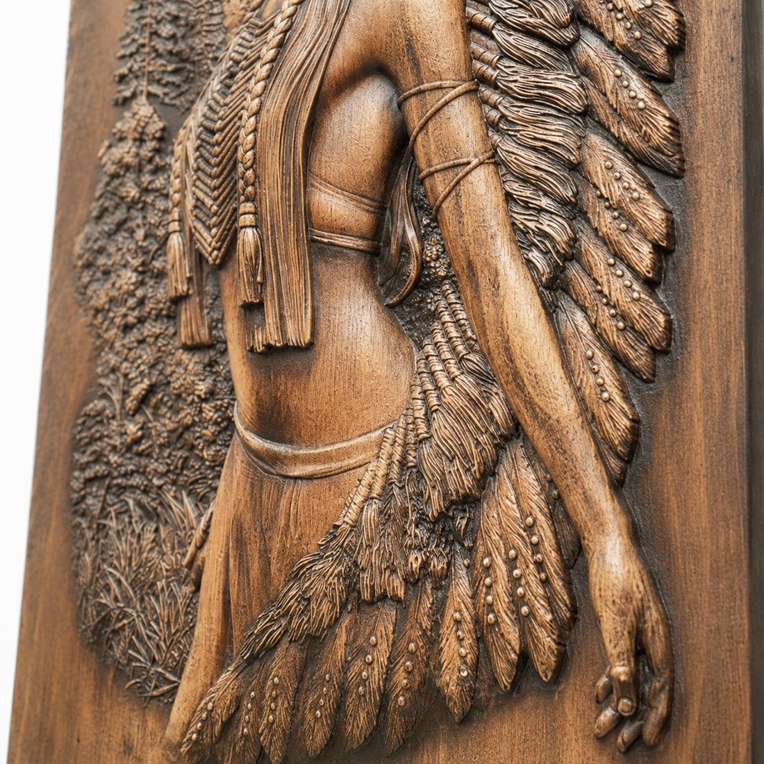 Close-up detail of the hand-carved wooden relief showing the body, feather skirt, and carved textures of the Native American woman wall art