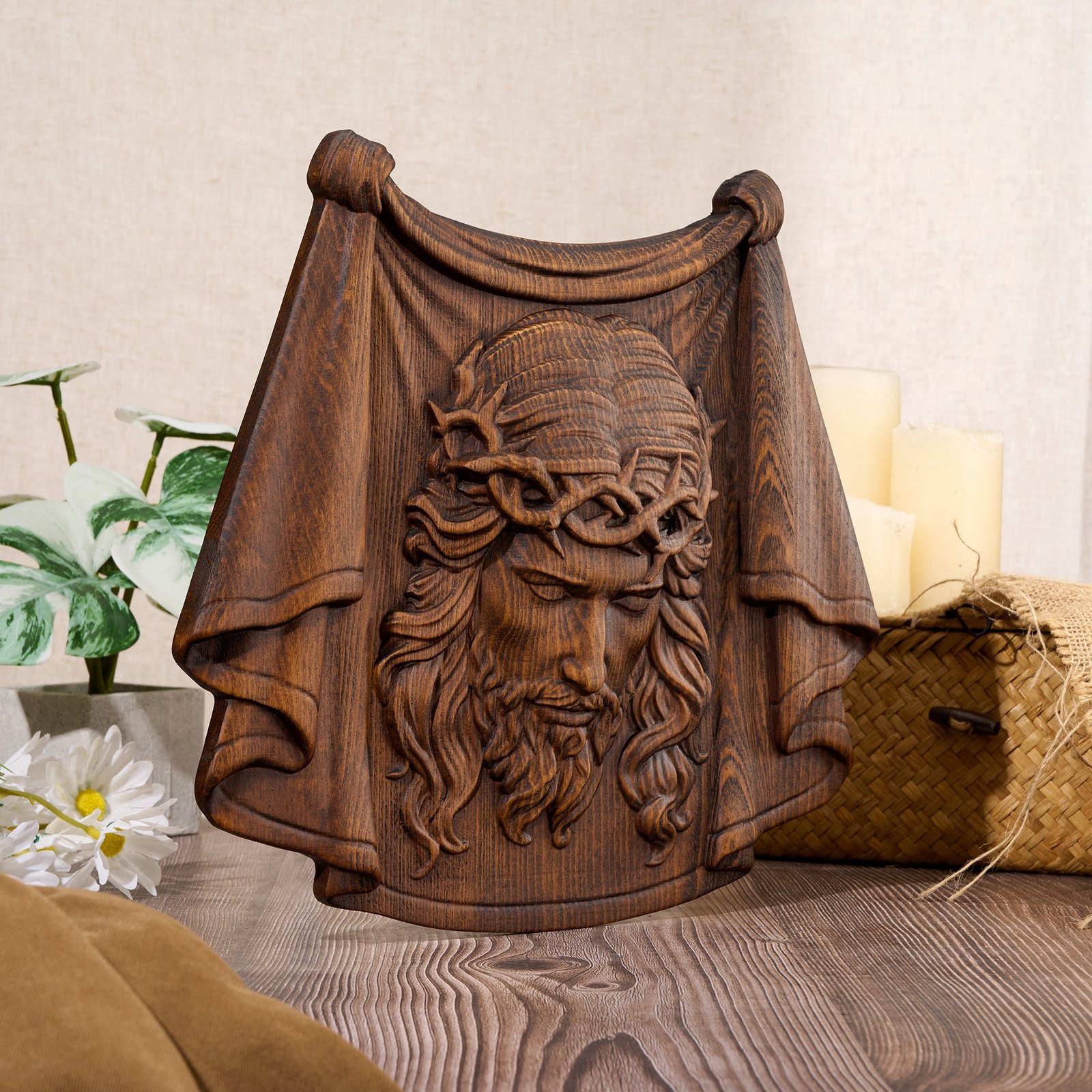 Rustic wooden relief plaque showing the face of Jesus with crown of thorns and flowing draped cloth